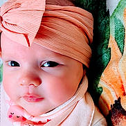 Madison joined the competition — help win amazing prizes! baby, infant, headband, bow, face, closeup, blanket, bib, clothing, cute, expression, portrait, skin, soft_lighting, child, newborn, lying_down, indoors, apparel, headwear