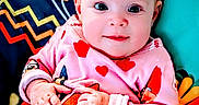 Madison is registered to the contest to win money with this photo: baby, bright_colors, cartoon_characters, child, childrens_clothing, colorful, cushion, cute, drool, face, hands, heart_pattern, indoors, infant, onesie, pattern, playful, portrait, sitting, young