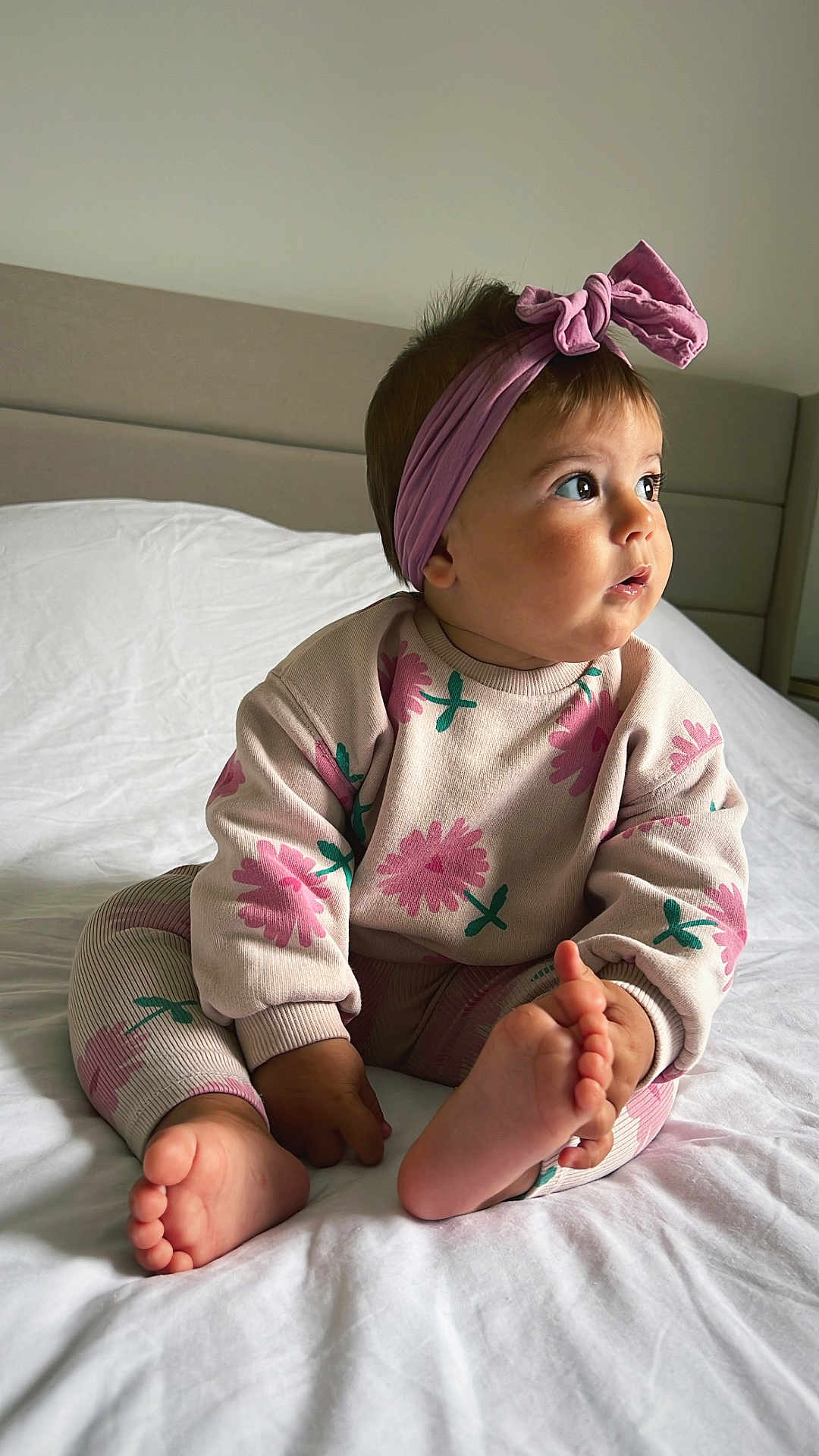 Saori a rejoint le concours — aidez-le/la à gagner de superbes lots ! baby, child, infant, bed, blanket, headband, pink_bow, floral_clothing, cute, indoors, portrait, feet, hands, sitting, expression, soft_lighting, cozy, childrens_fashion, curious, young