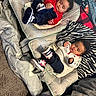 baby, toddler, infant, sleeping, awake, baby_seat, blanket, carpet, footwear, clothing, indoor, curly_hair, cute, resting, comfort, cozy, child, person, soft, relaxing