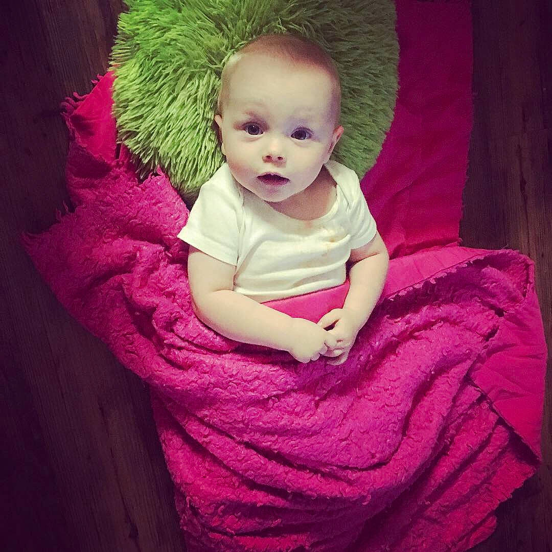 Connor is registered to the contest to win money with this photo: arm, baby, baby_products, cheek, child, eye, face, head, lip, magenta, person, pink, product, purple, skin, smile, textile, toddler