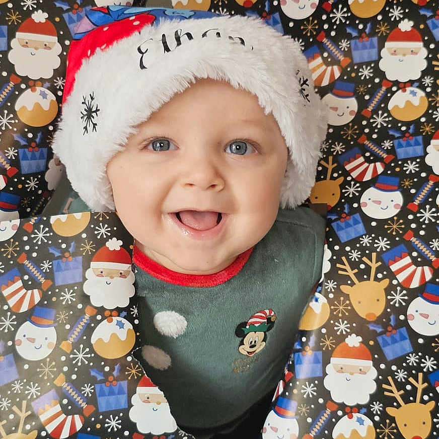 éthan participe au concours pour gagner de l'argent avec cette photo : baby, background, blue_eyes, child, christmas, christmas_wrapping_paper, cute, face, festive, gift_wrap, happy, holiday, mickey_mouse, portrait, reindeer, santa_hat, seasonal, smiling, snowman, sweater