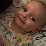 Charlie joined the competition — help win amazing prizes! baby, smile, pacifier, pillow, floral_clothing, couch, indoor, child, portrait, face, head, infant, cute, happy, lying_down, pattern, fabric, skin, eyes, cozy