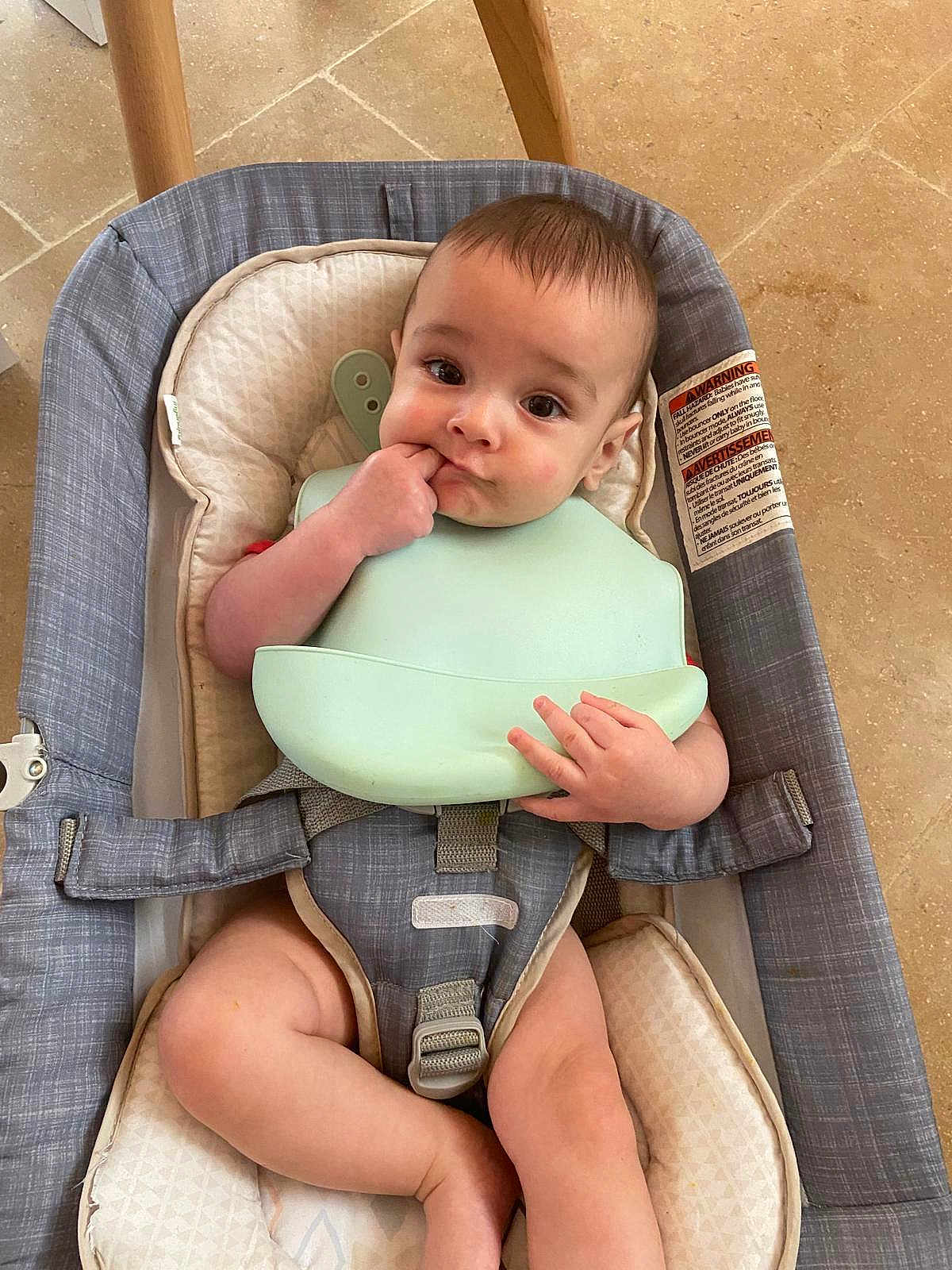 Aaron participe au concours pour gagner de l'argent avec cette photo : baby, child, infant, sitting, bib, baby_seat, cushion, hand, fingers, floor, wooden_leg, indoor, curious, face, head, legs, clothing, safety_belt, expression, cute