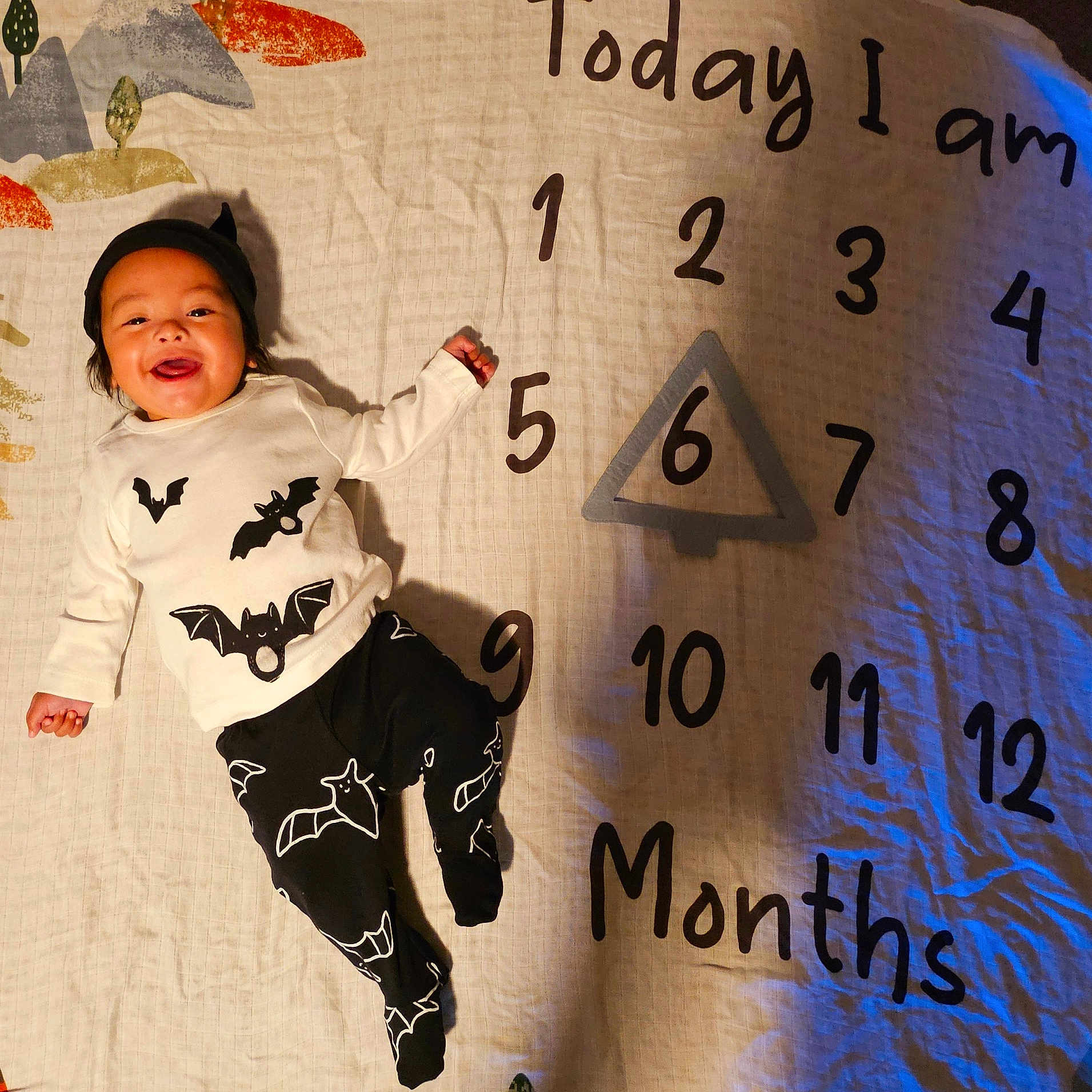 Marvin is registered to the contest to win money with this photo: baby, blanket, bodypart, clothing, face, finger, furniture, hand, hat, head, longsleeve, number, pants, person, photography, portrait, sleeve, symbol, t_shirt, text