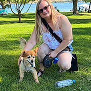 Rocky joined the competition — help win amazing prizes! woman, dog, grass, tree, lake, outdoor, sunny, leash, water_bottle, dog_bowl, sunglasses, casual_clothing, smiling, nature, park, summer, pet, recreation, people, shade