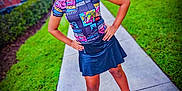 Isis is registered to the contest to win money with this photo: child, girl, sidewalk, outdoor, grass, trees, pigtails, smile, black_skirt, boots, colorful_shirt, hands_on_hips, residential_area, greenery, person, young_girl, fashion, casual, portrait, daylight