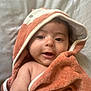 baby, child, towel, hood, smile, face, skin, arm, blanket, cute, infant, wrapped, soft, texture, happy, portrait, lying_down, indoors, closeup, expression