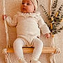 baby, infant, swing, knitwear, headband, wooden_swing, cozy, neutral_colors, indoor, soft_texture, plant, decor, cute, child, peaceful, portrait, sitting, warm_tones, fashion, young_child