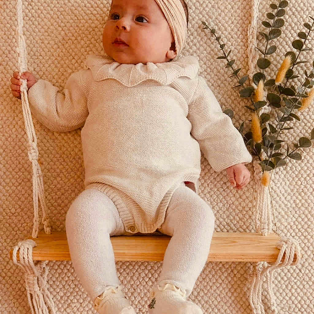 Eléanore a rejoint le concours — aidez-le/la à gagner de superbes lots ! baby, child, cozy, cute, decor, fashion, headband, indoor, infant, knitwear, neutral_colors, peaceful, plant, portrait, sitting, soft_texture, swing, warm_tones, wooden_swing, young_child