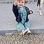 Lily a rejoint le concours — aidez-le/la à gagner de superbes lots ! toddler, child, flower, hair_accessory, smiling, jumping, dog, pet, stone_patio, brick_wall, flower_box, outdoor, playful, casual_clothing, sandal, green_outfit, black_jacket, happy, person, daylight