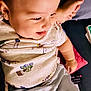 baby, child, smiling, tongue_out, headband, floral, shirt, shorts, cushion, sofa, indoors, happy, person, cute, toddler, relaxing, comfort, playful, face, skin
