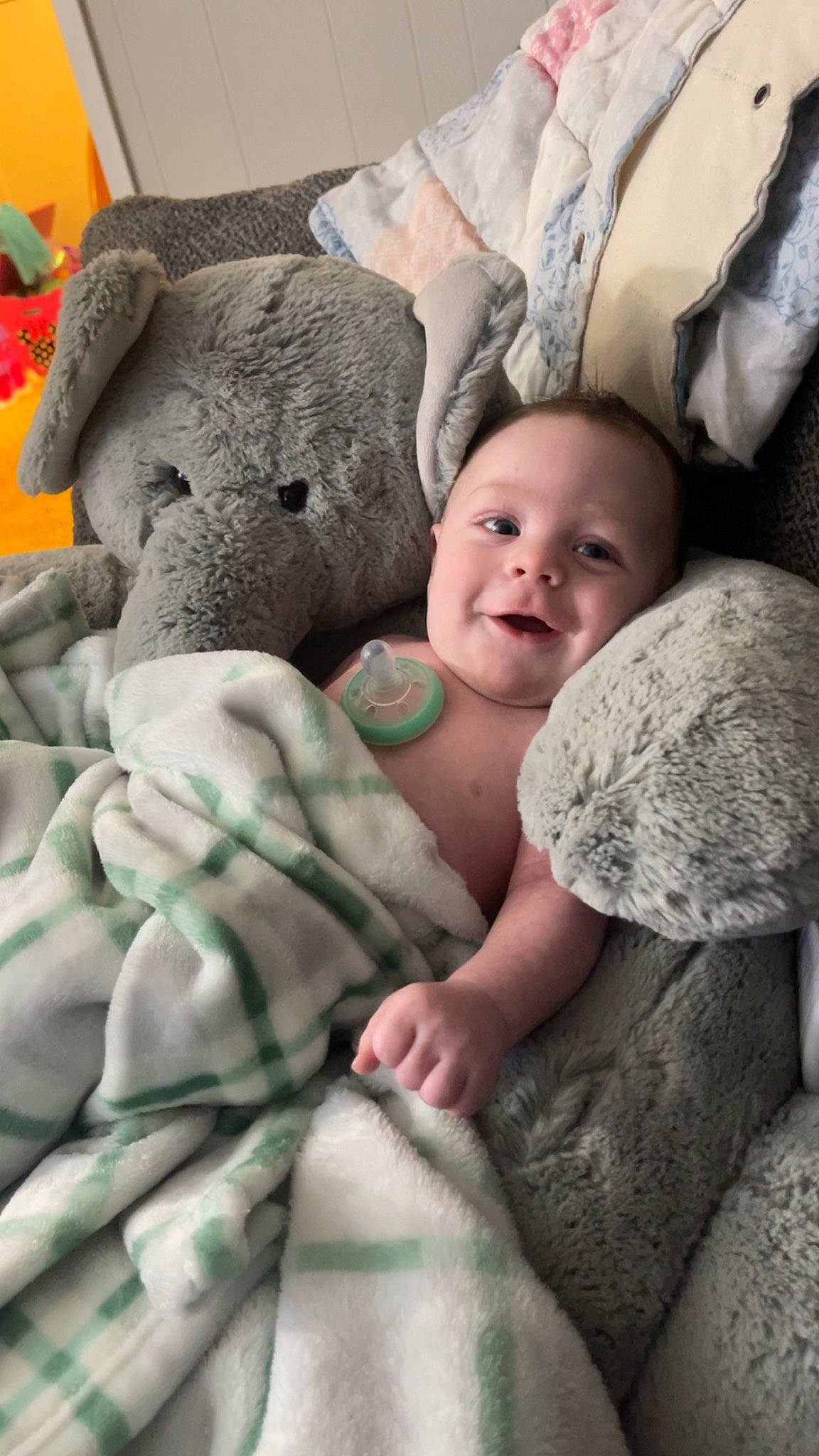 Kohen is registered to the contest to win money with this photo: baby, bedding, child, comfort, eye, finger, fur, gesture, grey, hand, happy, head, linens, mammal, pattern, person, sitting, skin, smile, textile