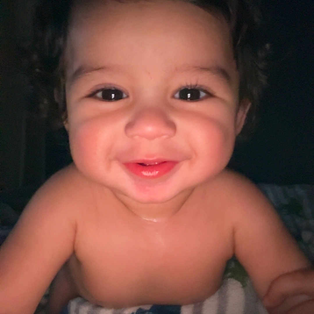 Mael joined the competition — help win amazing prizes! baby, child, smiling, curly_hair, blanket, striped_blanket, indoor, portrait, happy, cute, infant, face, skin, eyes, mouth, expression, toddler, young_child, person, closeup