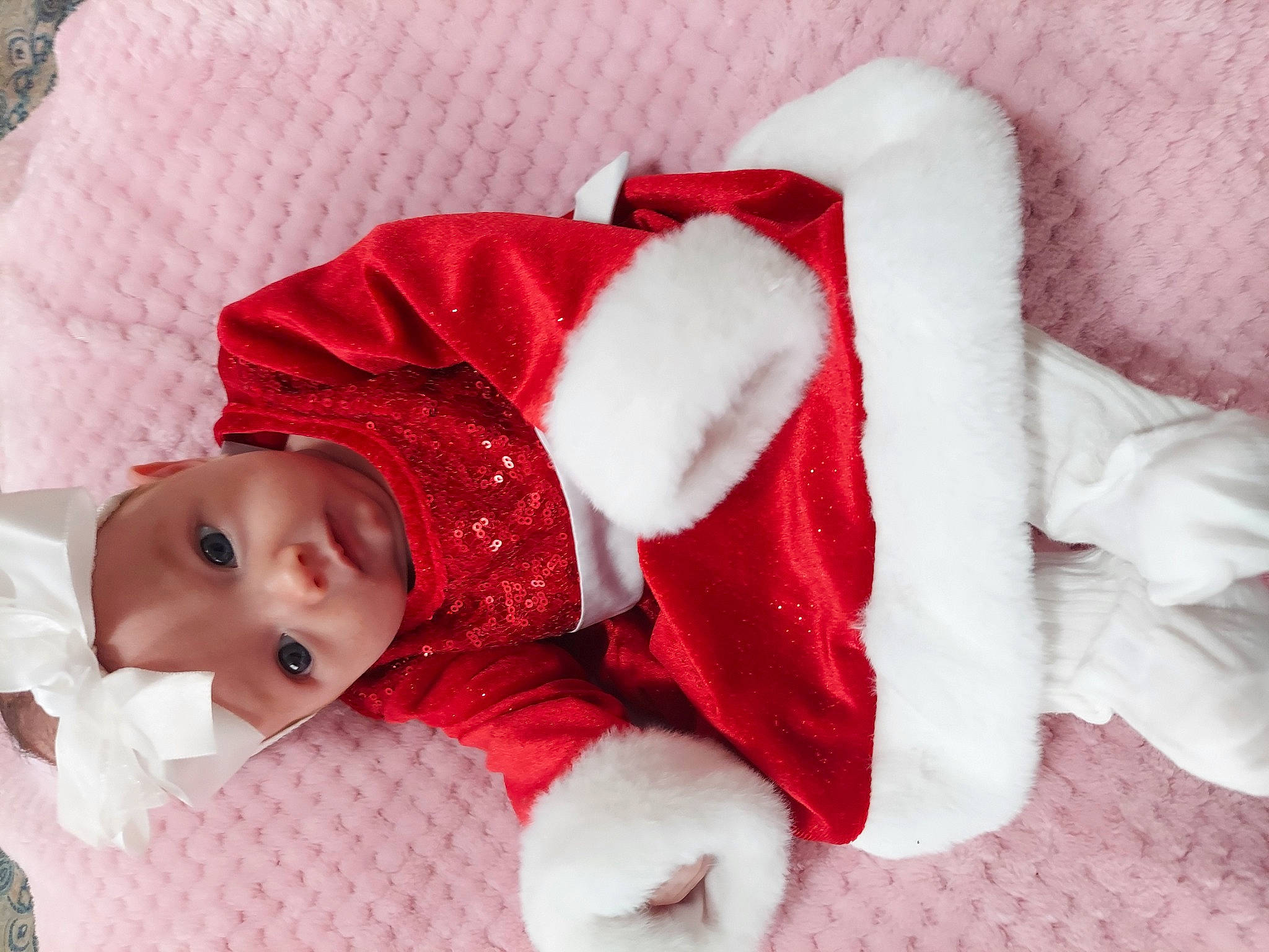 Leora joined the competition — help win amazing prizes! baby, baby_sleeping, baby_toddler_clothing, carmine, child, christmas, comfort, fictional_character, fur, hat, human_body, linens, pattern, person, room, santa_claus, sleeve, textile, toddler, winter