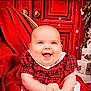 baby, smiling, red_dress, plaid, blanket, christmas_tree, gifts, holiday, festive, happy, indoor, child, cute, seasonal, celebration, decorations, portrait, sitting, warm, cheerful