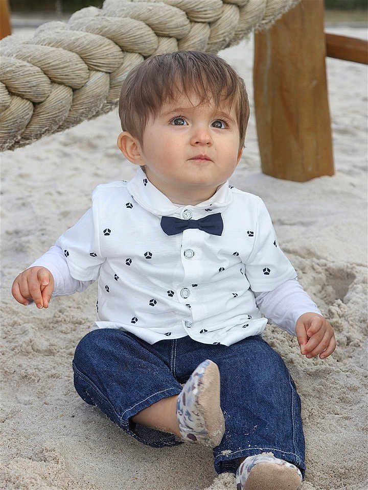 Augustin a rejoint le concours — aidez-le/la à gagner de superbes lots ! toddler, child, sand, outdoor, playground, rope, denim_pants, white_shirt, bow_tie, sitting, cute, curious, face, skin, hair, footwear, casual_clothing, daylight, young_child, expression