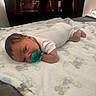 Kamari is registered to the contest to win money with this photo: baby, infant, pacifier, blanket, bed, tummy, sleepwear, curly_hair, indoors, soft_texture, resting, child, person, cute, newborn, cozy, quiet, young, portrait, relaxing