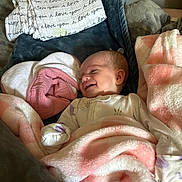 Heidi Lynn joined the competition — help win amazing prizes! baby, smiling, blanket, pink, white, pillow, cozy, sleepwear, infant, face, cute, child, soft, fabric, home, resting, comfort, happy, newborn, portrait