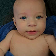 Gianni is registered to the contest to win money with this photo: baby, child, blue_eyes, towel, portrait, closeup, smile, skin, face, infant, person, cute, soft_light, indoors, young, head, bare_chest, warm, relaxed, comfort