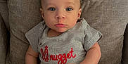 Gianni joined the competition — help win amazing prizes! baby, child, infant, shirt, shorts, couch, pillow, pacifier, sitting, face, hands, blue_eyes, gray, brown, clothing, indoor, portrait, cute, expression, furniture