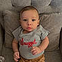 baby, child, infant, shirt, shorts, couch, pillow, pacifier, sitting, face, hands, blue_eyes, gray, brown, clothing, indoor, portrait, cute, expression, furniture