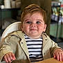 toddler, child, high_chair, striped_shirt, beige_jacket, smile, face, table, indoor, person, cute, rosy_cheeks, eyes, hand, clothing, portrait, baby, happy, furniture, seated