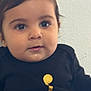 baby, child, face, eyes, black_clothing, gold_design, portrait, closeup, curious, indoor, young, infant, cute, chubby_cheeks, person, head, expression, skin, hair, sitting