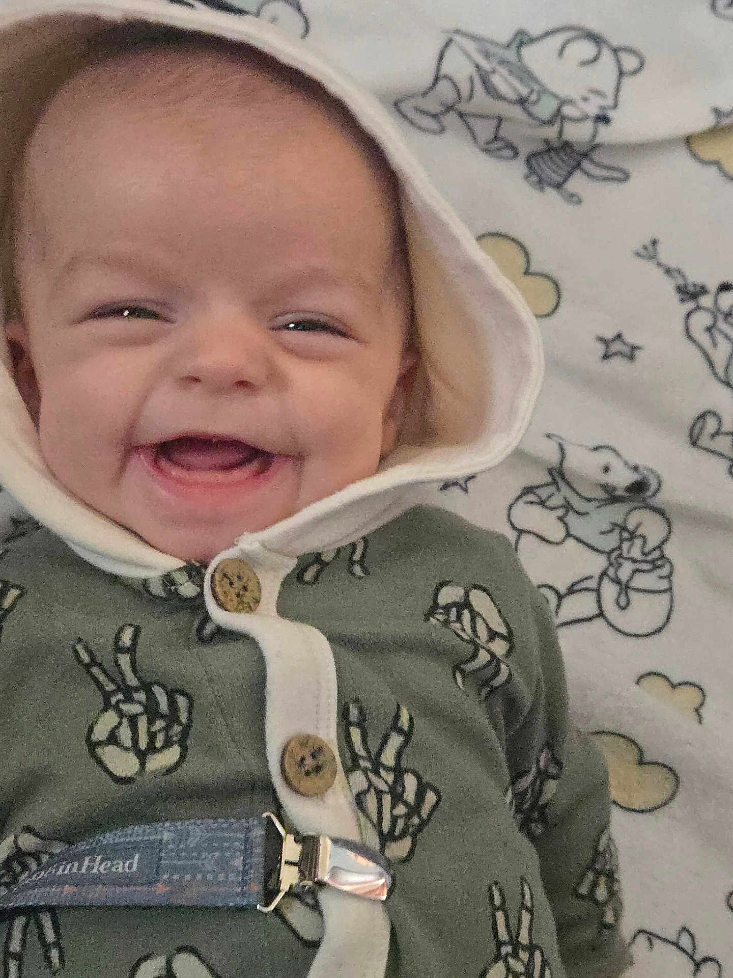 Sonnie joined the competition — help win amazing prizes! baby, smile, hood, clothing, peace_sign, button, blanket, cartoon, bear, cloud, happy, face, infant, child, cute, lying_down, fabric, pattern, comfort, indoors