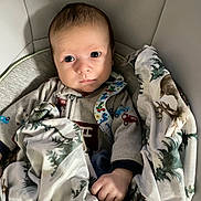 Damion joined the competition — help win amazing prizes! baby, infant, blanket, clothing, pattern, face, hand, cushion, seat, indoors, portrait, expression, cozy, child, young, cute, bundle, warm, resting, curious