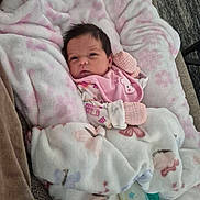 Kinsley is registered to the contest to win money with this photo: baby, newborn, blanket, pink, mittens, bottle, couch, infant, cute, soft, cozy, face, portrait, indoors, resting, sleepwear, child, person, warm, comfort