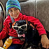 Circee is registered to the contest to win money with this photo: beverage, bottle, car_interior, child, companions, cute, dog, friendship, happy, hat, indoors, pet, red_hoodie, seatbelt, service_dog, shorts, smiling, sunglasses, tongue_out, travel