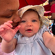 Milani is registered to the contest to win money with this photo: baby, child, person, adult, hat, smile, face, closeup, outdoor, umbrella, red, clothing, happy, love, nuzzle, skin, portrait, hand, cute, tender