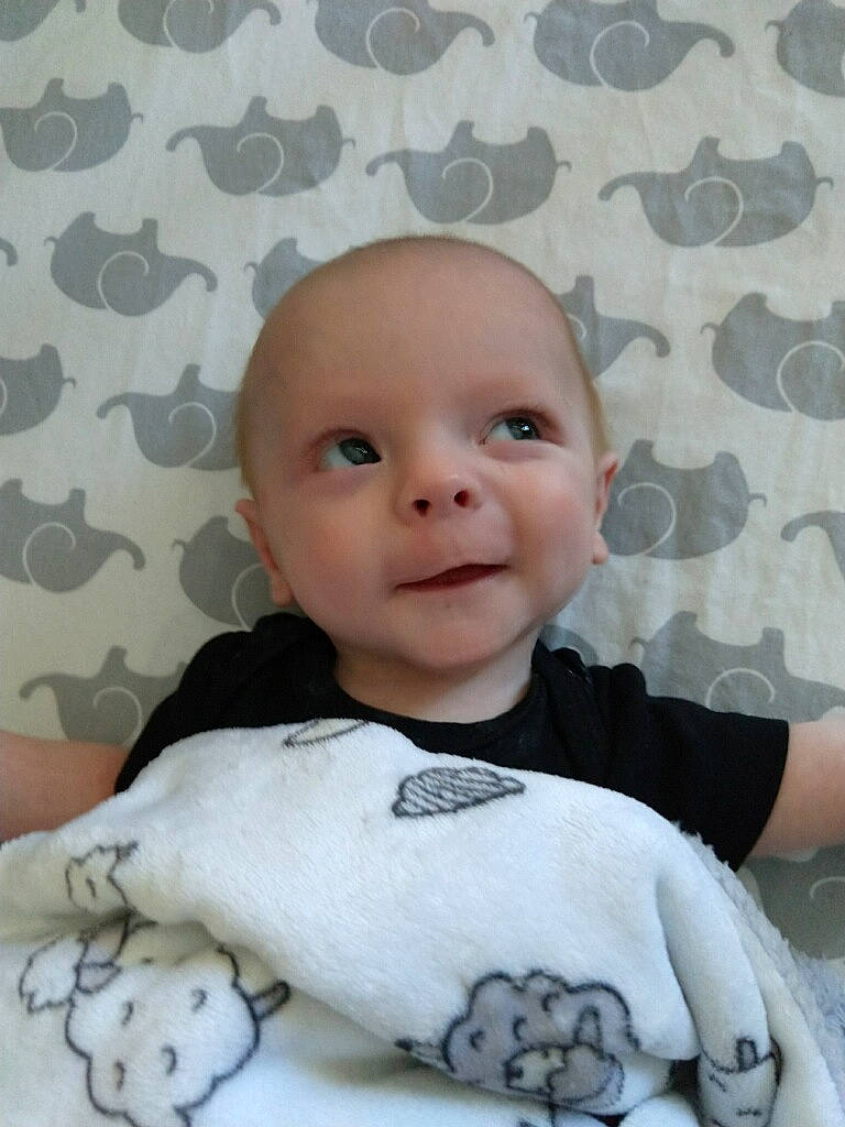 Vash is registered to the contest to win money with this photo: baby, baby_products, baby_toddler_clothing, cheek, child, comfort, finger, happy, head, linens, nose, pattern, person, pink, sitting, skin, sleeve, smile, textile, toddler