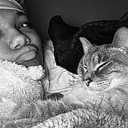 Storm is registered to the contest to win money with this photo: black_and_white, cat, person, face, closeup, blanket, cozy, indoor, sleepy_cat, headscarf, portrait, fur, whiskers, relaxing, cuddling, soft_texture, comfort, resting, animal, pet