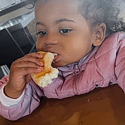 Talya participe au concours pour gagner de l'argent avec cette photo : child, toddler, donut, eating, crumbs, pink_jacket, curly_hair, face, hand, portrait, indoor, table, bite, food, pastry, candid, eyes, long_eyelashes, meal, cozy