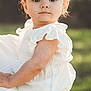 toddler, child, white_clothing, headband, bow, baby, portrait, outdoor, nature, greenery, hand, watch, ring, cute, young, innocent, soft_light, summer, person, holding