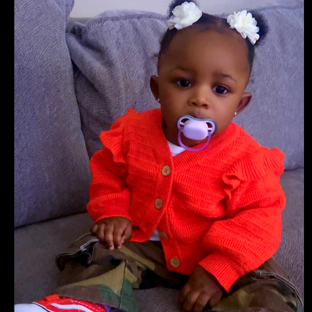 Nevaeha joined the competition — help win amazing prizes! baby, camouflage_pants, casual_clothing, child, couch, cozy, cute, fashion, flower_hair_accessories, gray_couch, home, indoors, orange_sweater, pacifier, person, portrait, red_shoes, sitting, toddler, young_child