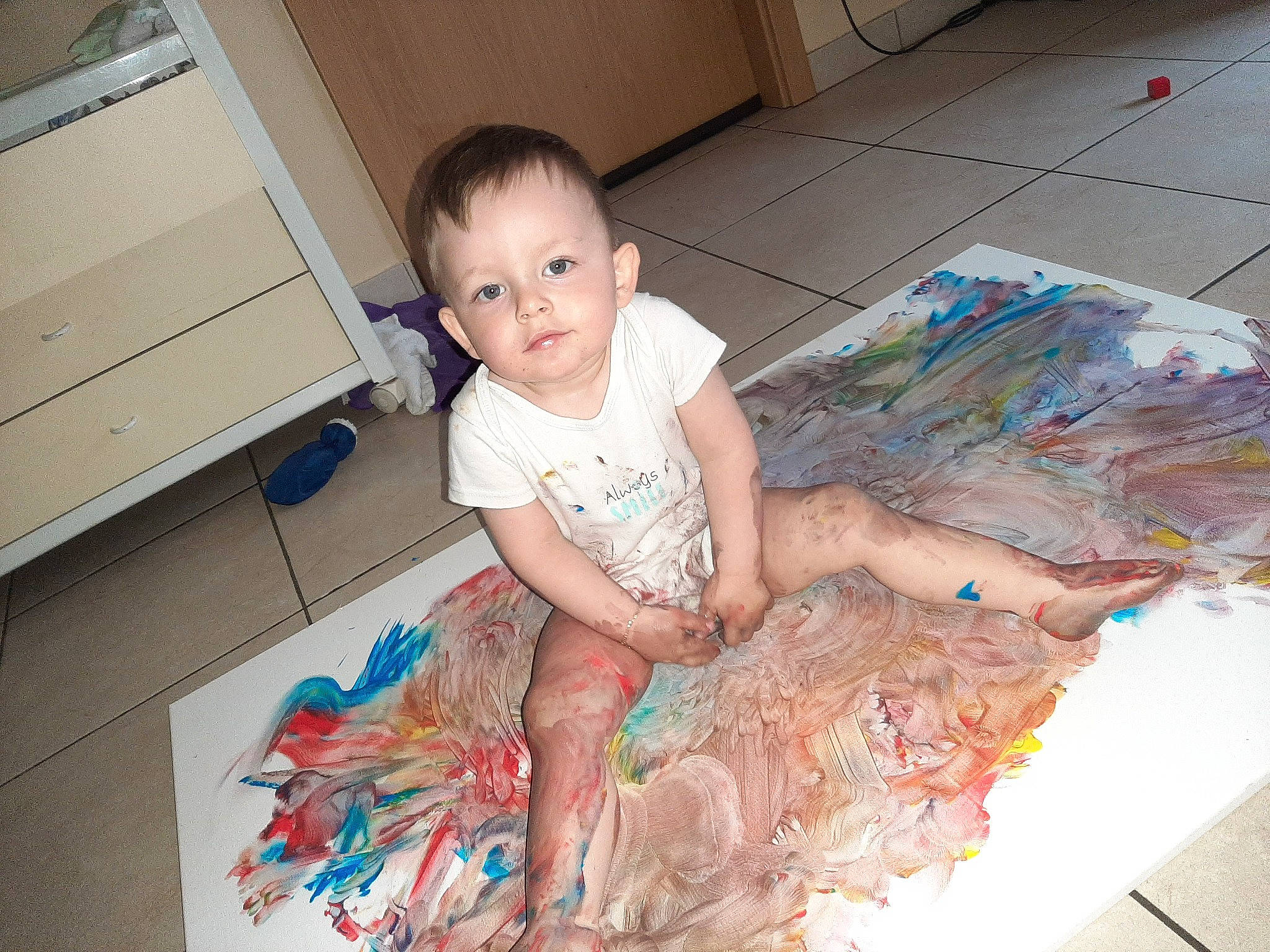 Damon a rejoint le concours — aidez-le/la à gagner de superbes lots ! art, baby, baby_toddler_clothing, barefoot, box, child, drawer, floor, flooring, foot, fun, hardwood, human_leg, pattern, person, room, sitting, t_shirt, thigh, toddler