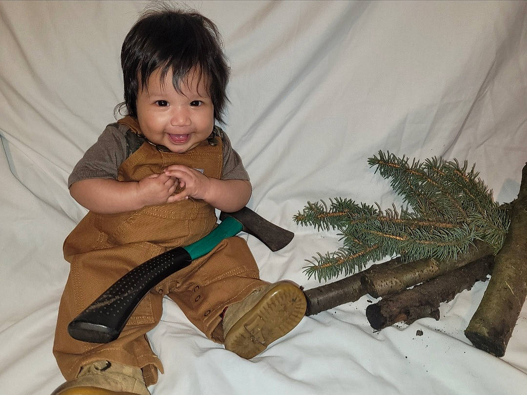 Yahritza is registered to the contest to win money with this photo: baby, baby_toddler_clothing, child, conifer, fawn, foot, fun, hairstyle, happy, human_body, joy, outerwear, person, sitting, skin, sleeve, smile, sock, thigh, toddler