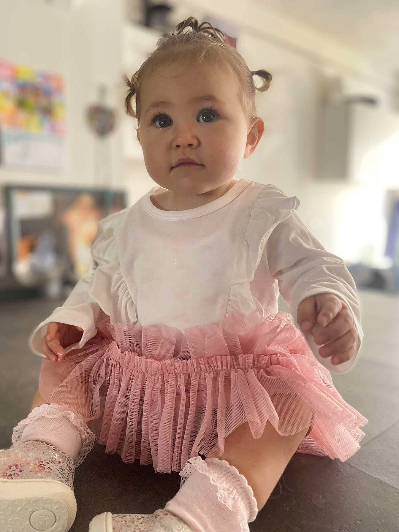 Agathe a rejoint le concours — aidez-le/la à gagner de superbes lots ! baby, baby_toddler_clothing, child, day_dress, embellishment, face, fashion_accessory, happy, human_leg, iris, pattern, peach, person, pink, ruffle, sitting, skin, sleeve, thigh, toddler