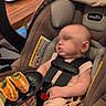 baby, sleeping, car_seat, taco, food, restaurant, table, chair, straps, infant, cute, meal, indoor, person, head, clothing, seat, peaceful, hand, caption