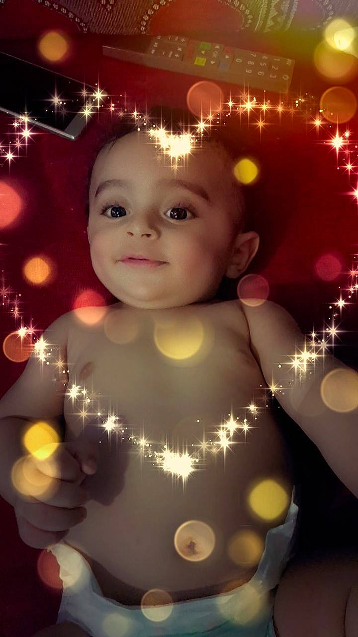 Ilyan participe au concours pour gagner de l'argent avec cette photo : baby, cheek, child, christmas, christmas_decoration, christmas_lights, christmas_ornament, christmas_tree, face, head, headwear, holiday, interior_design, lighting, person, sky, smile, toddler