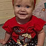 baby, child, smiling, headband, bow, red_shirt, cartoon_character, heart_shaped_glasses, polka_dot_leggings, white_socks, frills, indoor, bed, blanket, cute, happy, person, portrait, infant, clothing