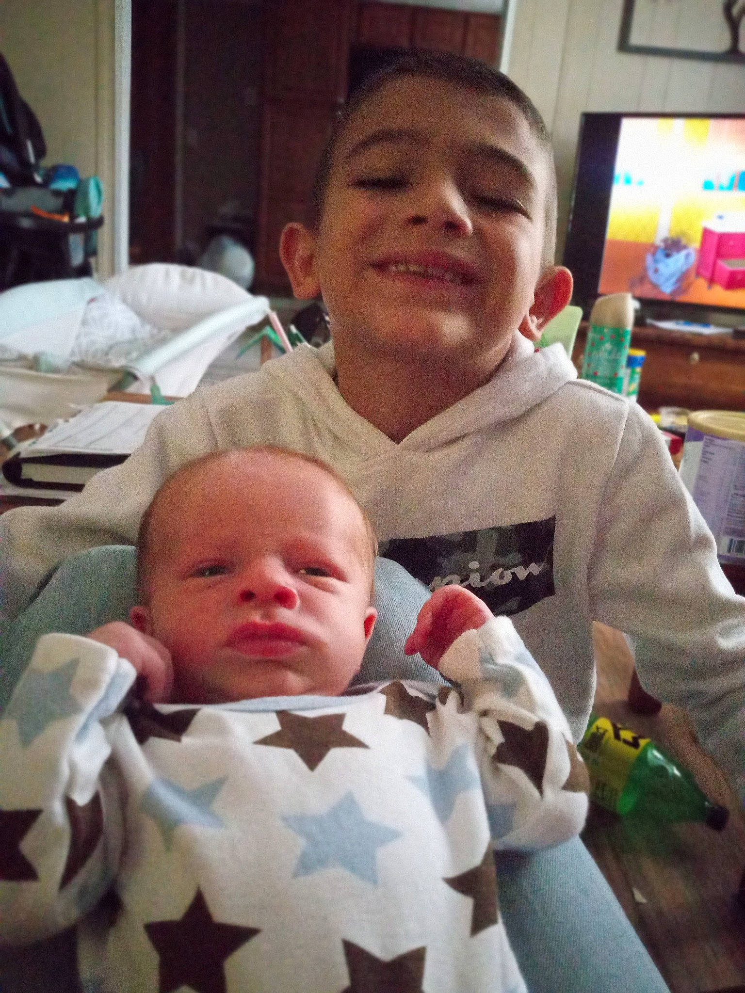 Hayden is registered to the contest to win money with this photo: baby, baby_toddler_clothing, cheek, child, comfort, event, finger, fun, happy, head, joy, mouth, organ, people, person, room, skin, smile, t_shirt, television