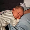 baby, sleeping, striped_onesie, infant, plush_toy, elephant_plush, bedroom, headboard, soft_fabric, cozy, peaceful, child, portrait, resting, indoors, cute, person, closeup, toddler, naptime