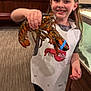child, girl, lobster, claws, blue_band, apron, smile, holding, indoor, restaurant, aquarium_tank, wood_paneling, carpet, leggings, shoes, hand, portrait, seafood, happy, earring