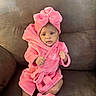 baby, child, pink_robe, headband, bow, slippers, couch, furniture, indoor, infant, cute, portrait, sitting, soft_texture, cozy, home, person, apparel, raised_fists, curious