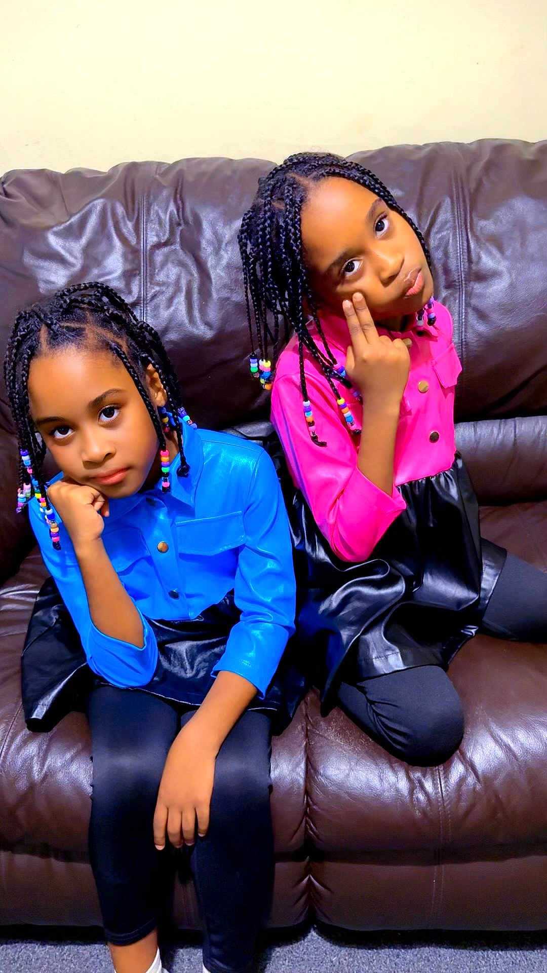 Arianna And Brianna is registered to the contest to win money with this photo: child, girl, braided_hair, beads, blue_shirt, pink_shirt, black_skirt, leggings, brown_couch, indoor, pose, expression, sitting, furniture, person, portrait, fashion, cute, colorful, hair_accessories