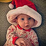 baby, blanket, child, christmas, cozy, cute, festive, hands, holiday, indoors, infant, laying_down, onesie, pajamas, portrait, red_hat, santa_hat, smiling, soft_texture, wide_eyes